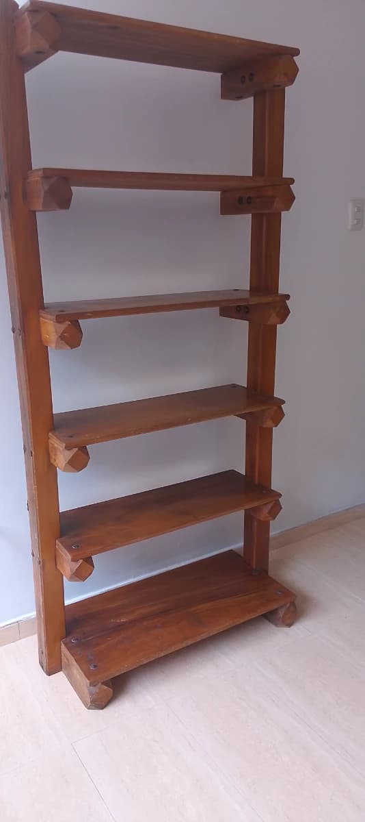Es un mueble tipo biblioteca de madera, abierto.